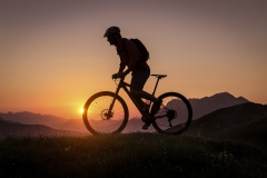 Silhouette of a male mountainbiker at sunset in the mountains